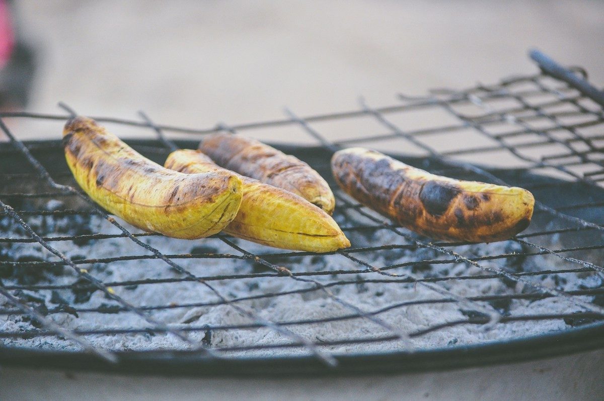 Deux bananes plantain très mûres, à la peau noircie, sur une grille